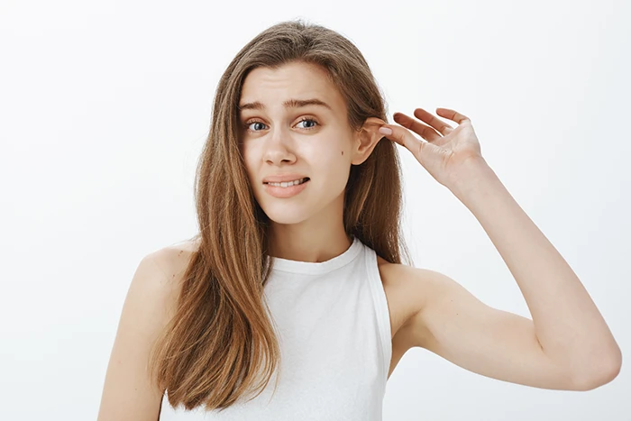 A woman pulling her ear