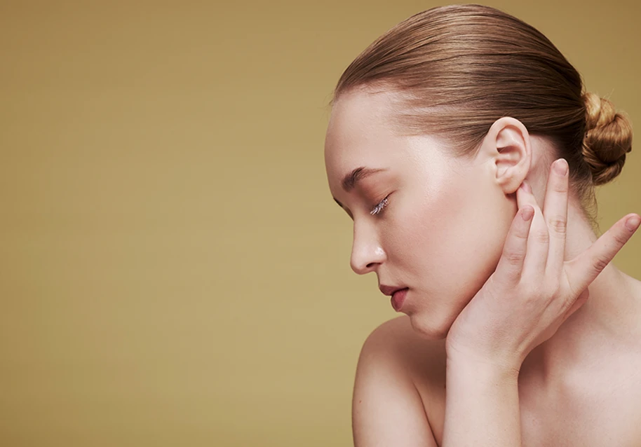 A woman posing while touching her ear