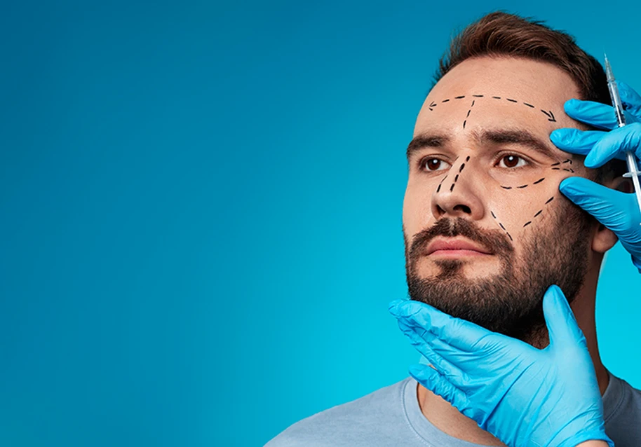 A cosmetic surgeon marking a man’s face for facelift surgery